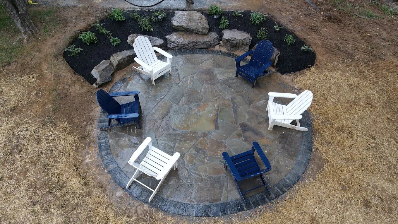 Round flagstone patio with Adirondack chairs built by Empire Landscapes